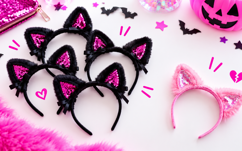 Four black sequin cat-ear headbands in a row and one pink pair set apart